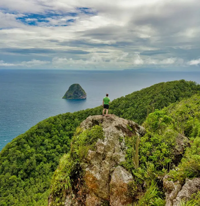person standing on rock near body of water during daytime